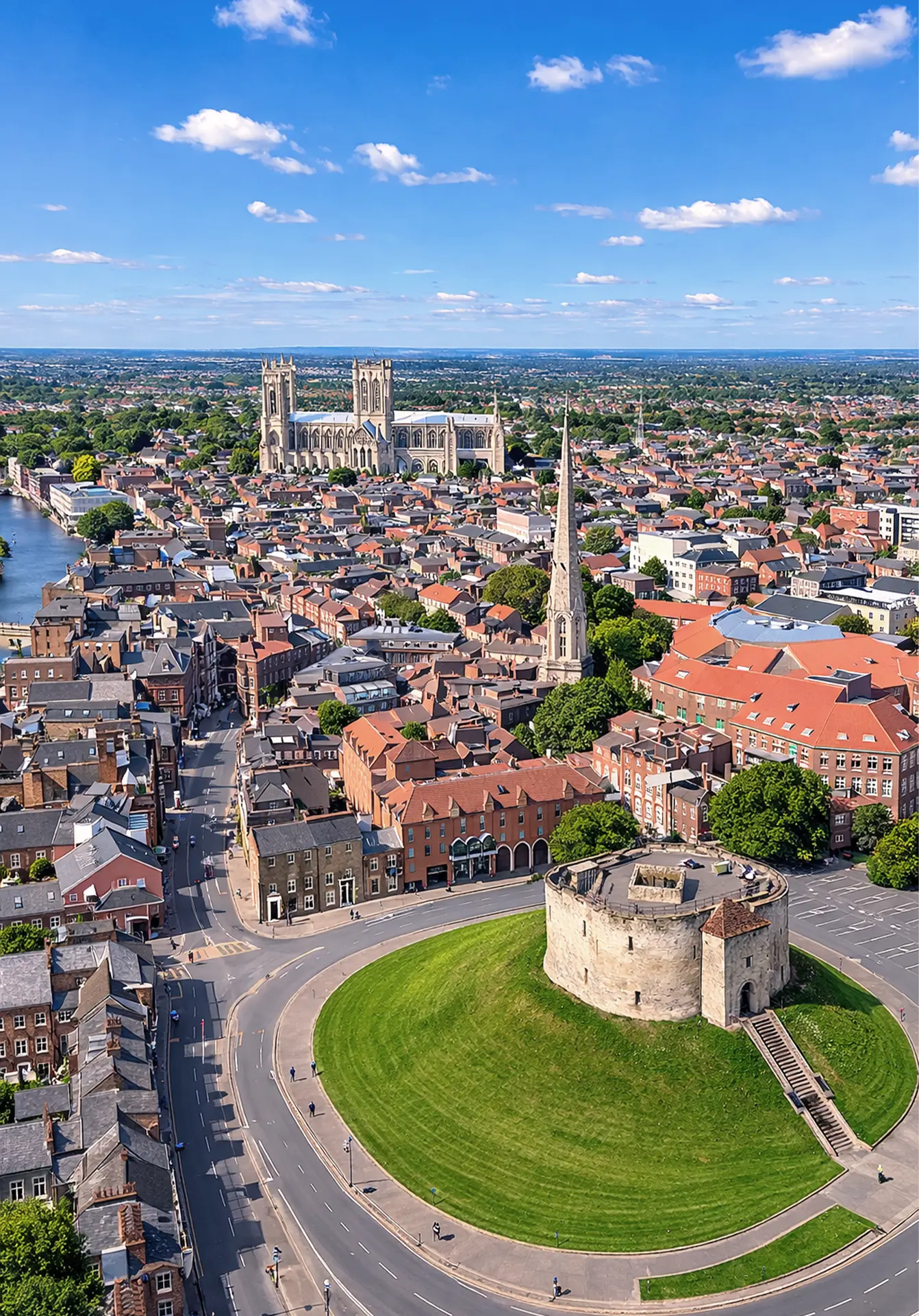 Clifford’s Tower in the foreground with York Minster behind on a clear sunny day in York
