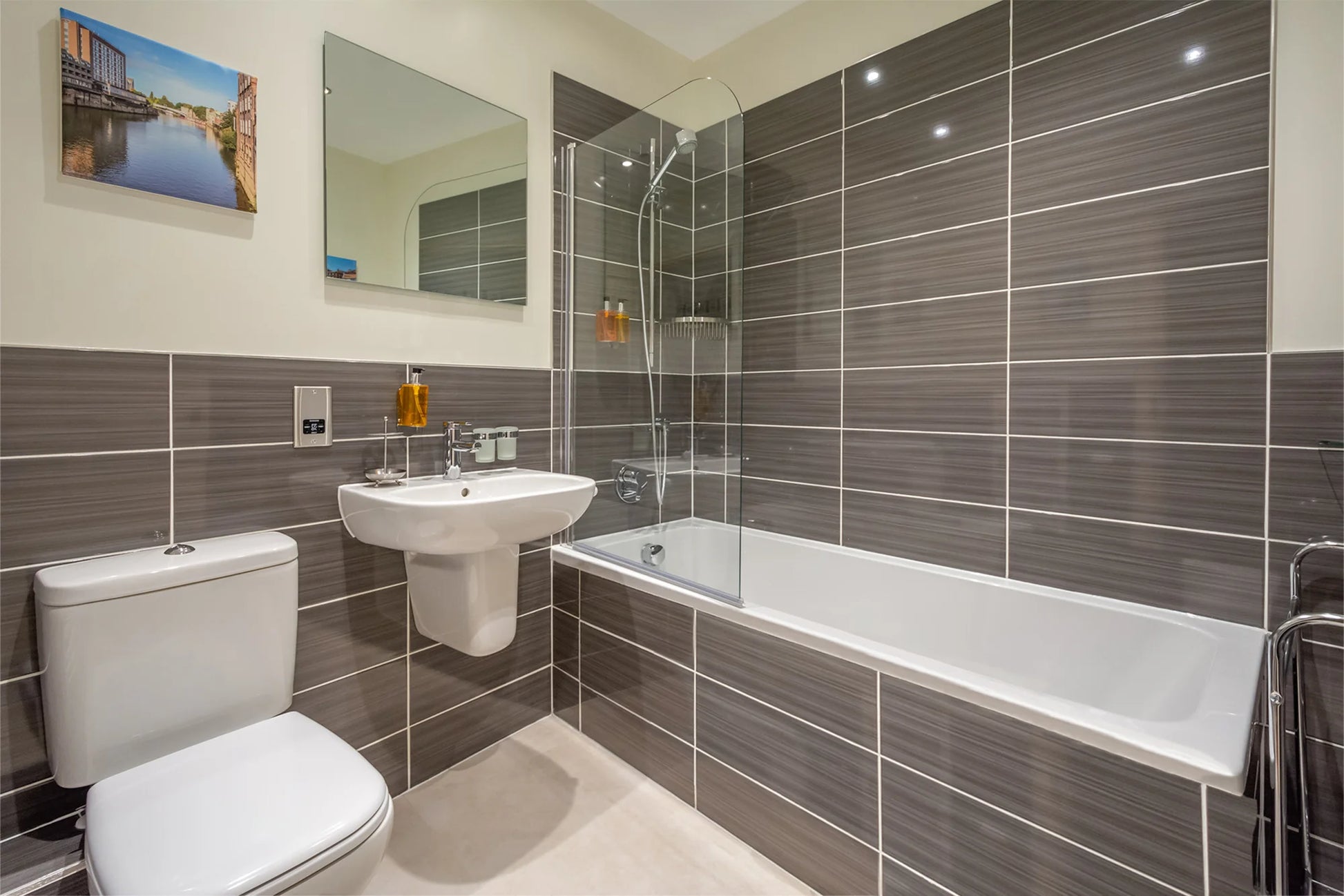 Hunter House Apartment bathroom with bath, shower and grey tiling in York city centre