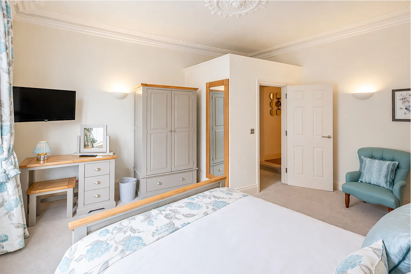 Bedroom with wardrobe, dressing table and armchair at Hunter House Apartment York