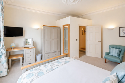Bedroom with wardrobe, dressing table and armchair at Hunter House Apartment York