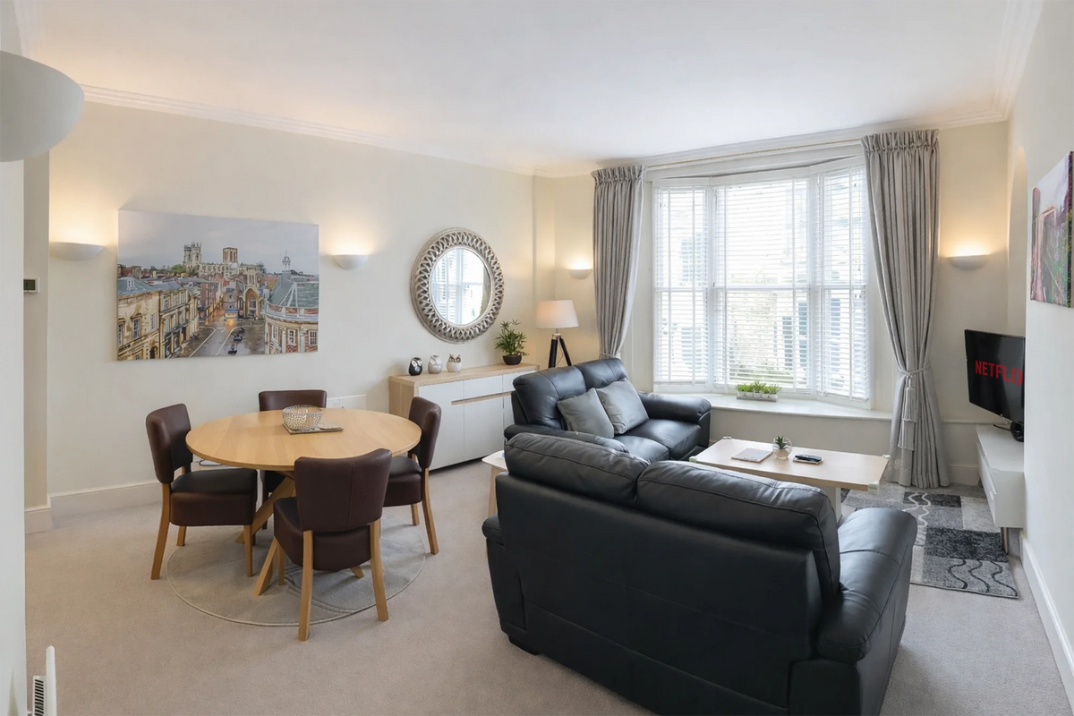 Hunter House Apartment dining area with round table and leather chairs in York city centre