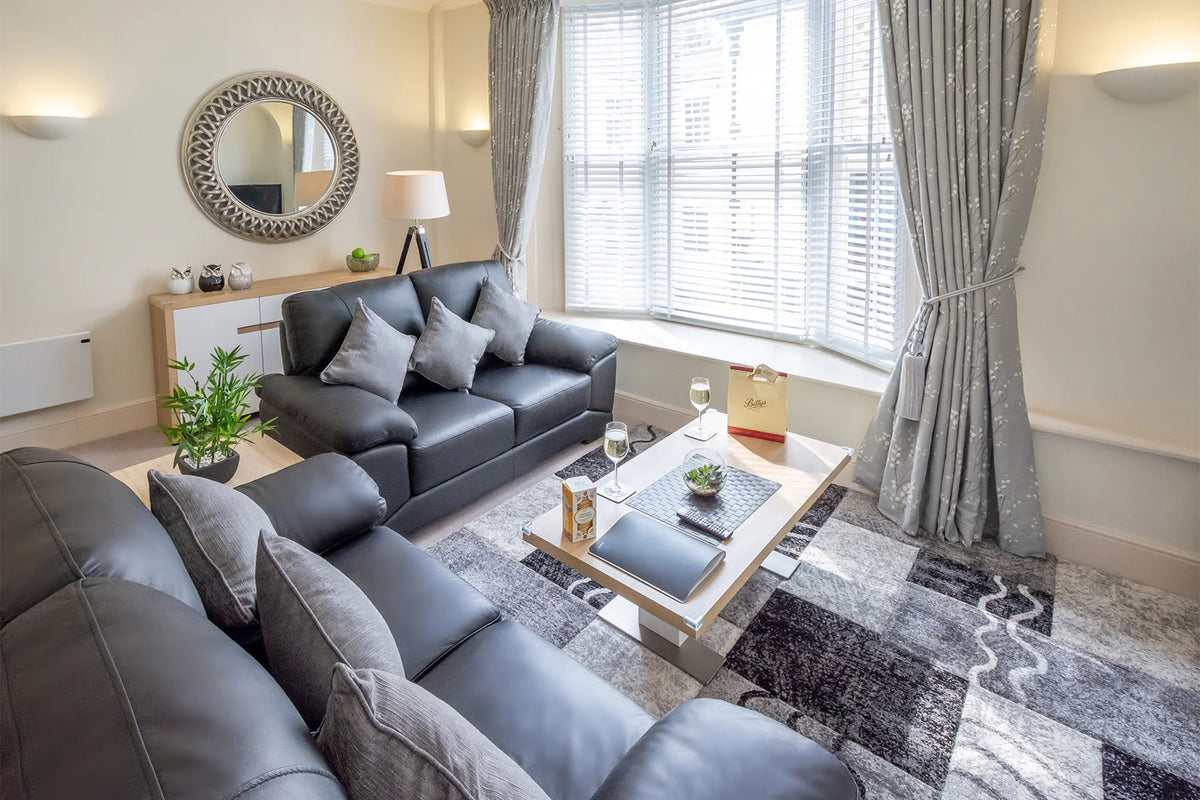 Hunter House Apartment lounge with sofa and large window in York city centre