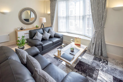 Hunter House Apartment lounge with sofa and large window in York city centre