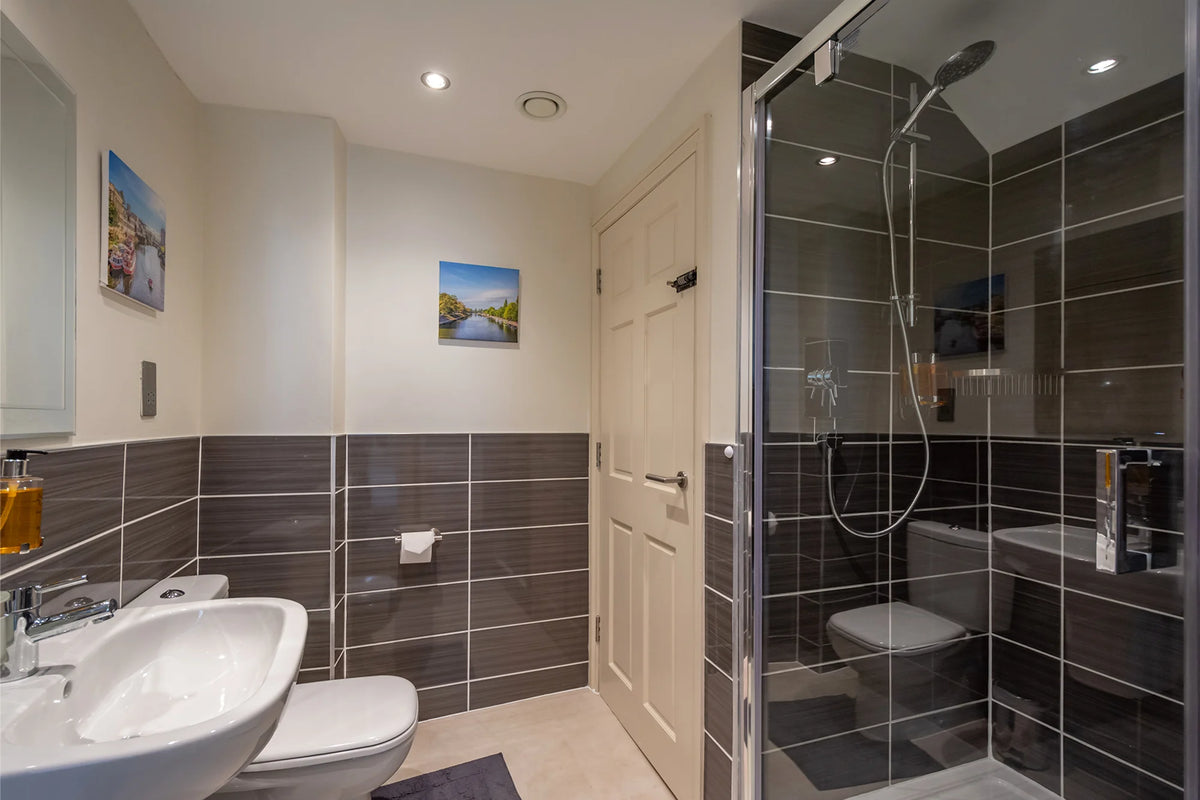 Hunter House Apartment bathroom with sink, toilet and shower area in York city centre