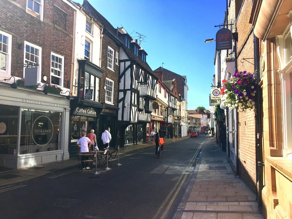 Timber-framed buildings, shopfronts and hanging flowers along Goodramgate in York