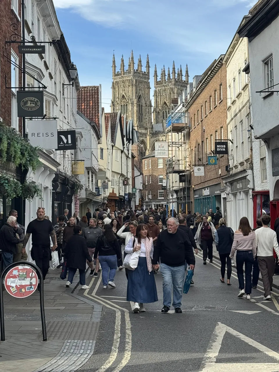 York Minster rising above the shops and people on Low Petergate